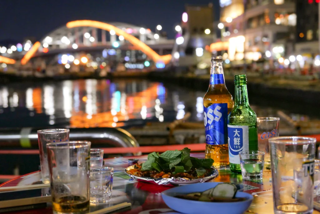 Outdoor pocha dining area at Yeongdo Pocha Street in Busan, South Korea, with Korean food and drinks at night